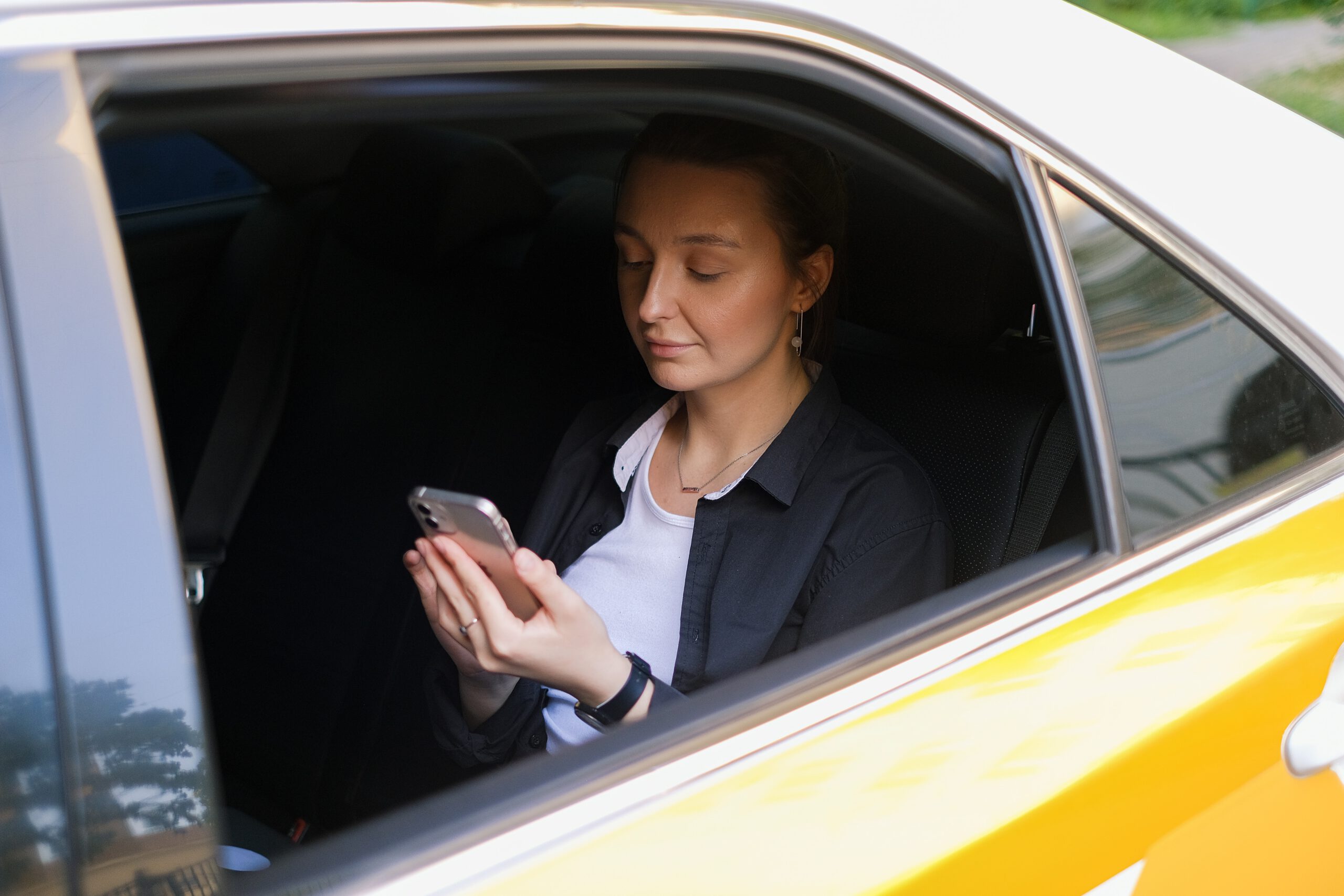 Kobieta z telefonem w ręce siedząca w samochodzie