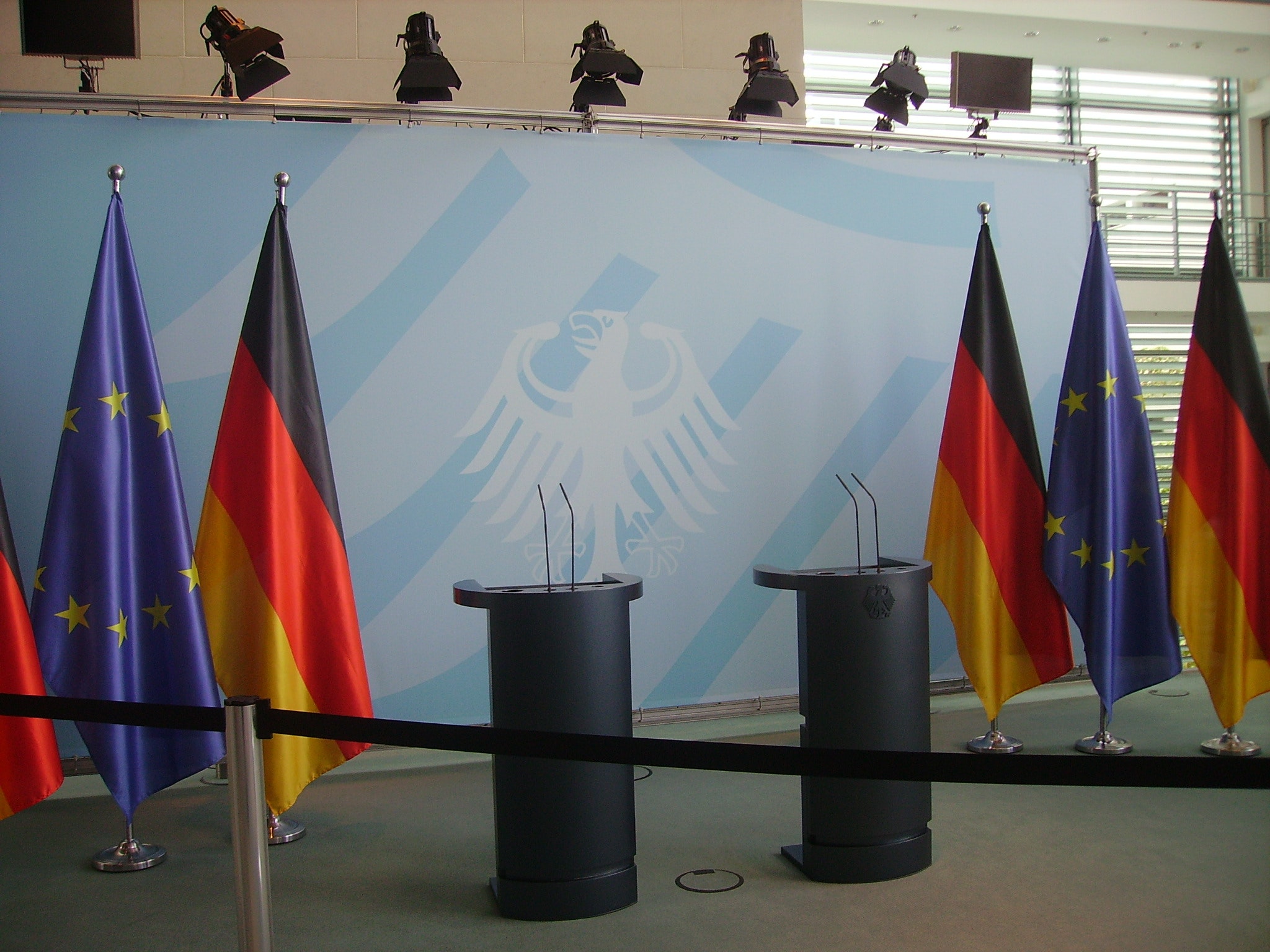 Stanowisko przygotowane do przeprowadzenia konferencji prasowej z mównicami i flagami