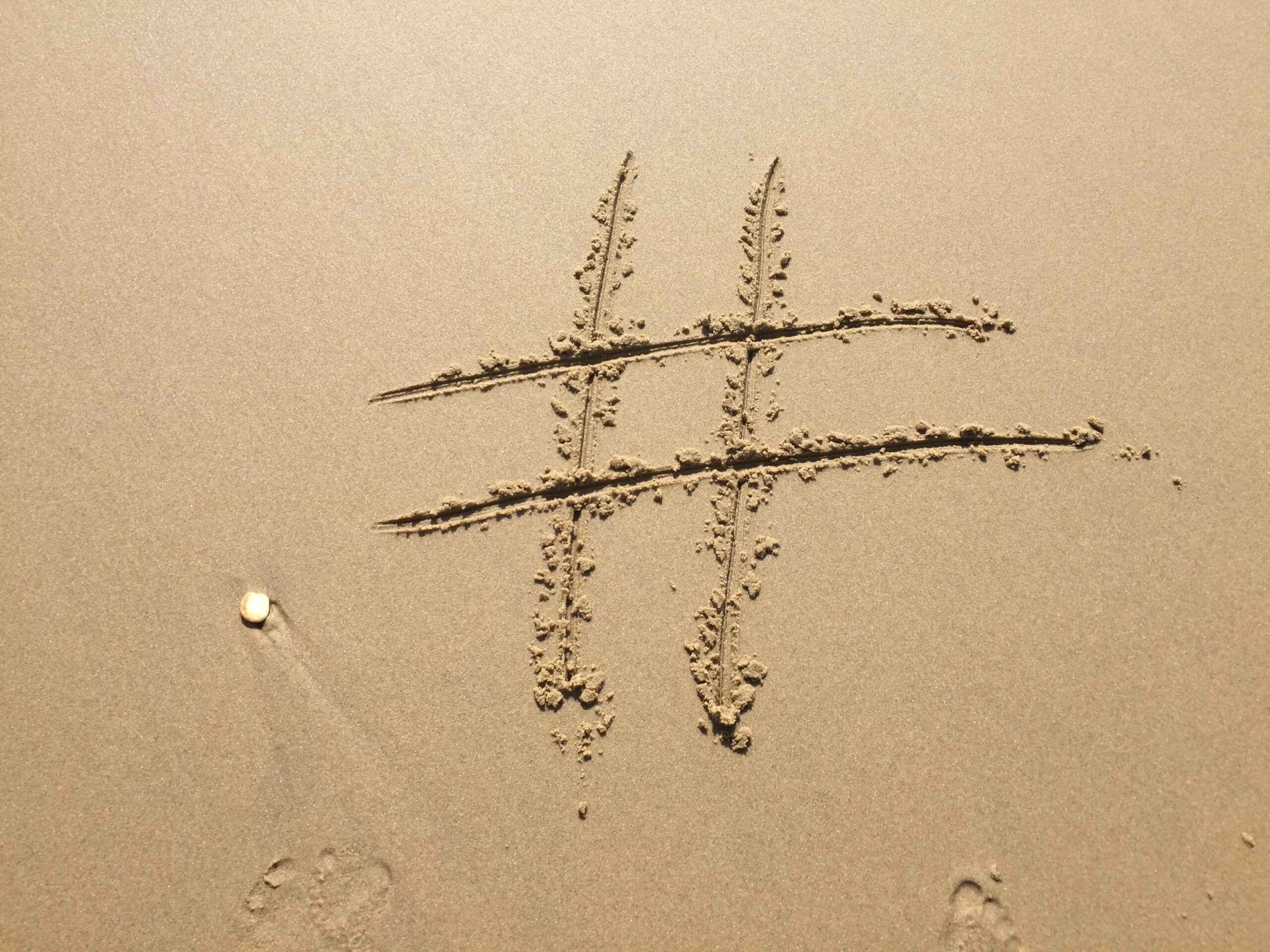 Symbol hasztagu wyryty w piasku